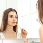 young woman brushing teeth